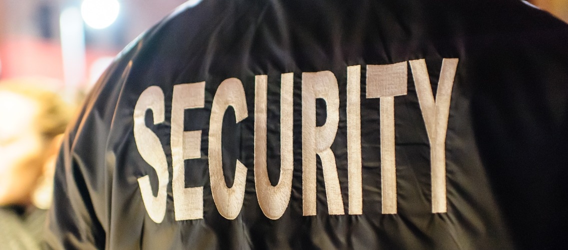 The word "security" on the back of a security guard's jacket.